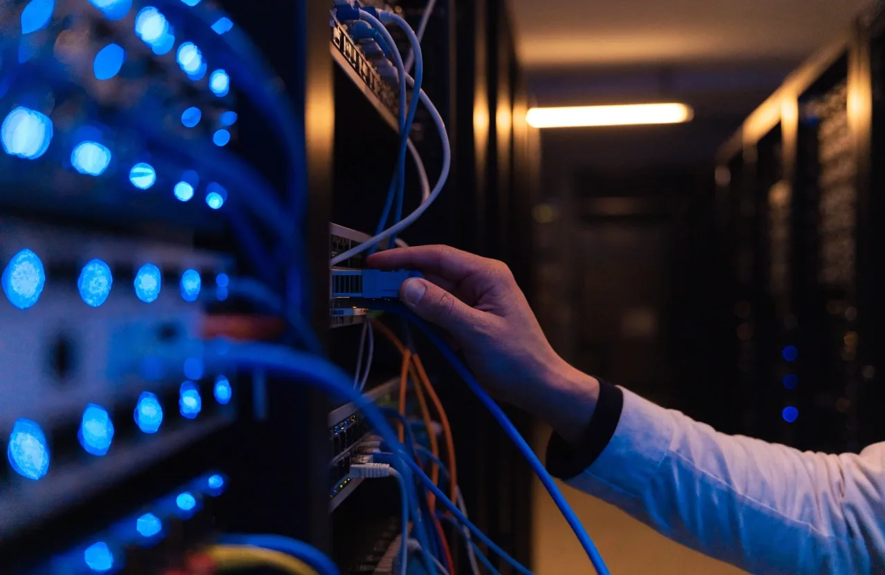 Cold blue rack light along a fogged server-room aisle at night